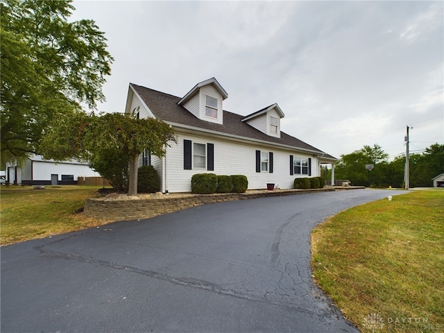 cape cod house featuring a front lawn