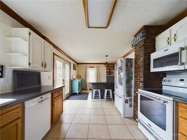 kitchen featuring a textured ceiling, white appliances, light tile patterned floors, crown molding, and white cabinetry