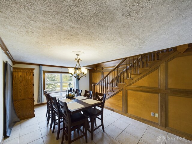 dining area with ornamental molding, a textured ceiling, an inviting chandelier, and light tile patterned flooring