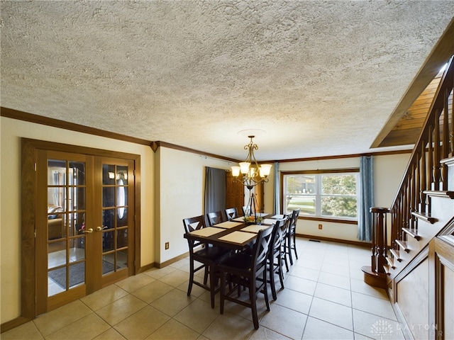 tiled dining room featuring french doors, a notable chandelier, and a textured ceiling