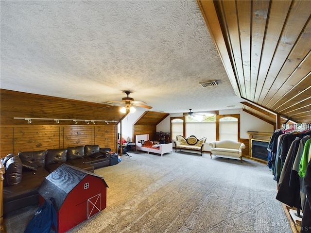 additional living space featuring a textured ceiling, ceiling fan, carpet floors, and vaulted ceiling