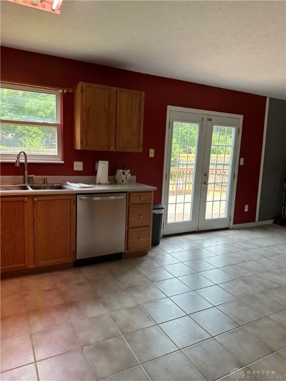 kitchen with plenty of natural light, stainless steel dishwasher, sink, and french doors