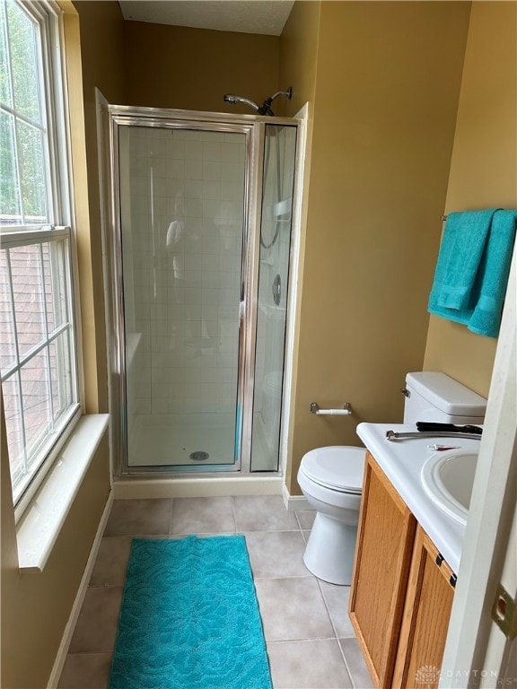 bathroom with a shower with shower door, tile patterned flooring, toilet, and vanity