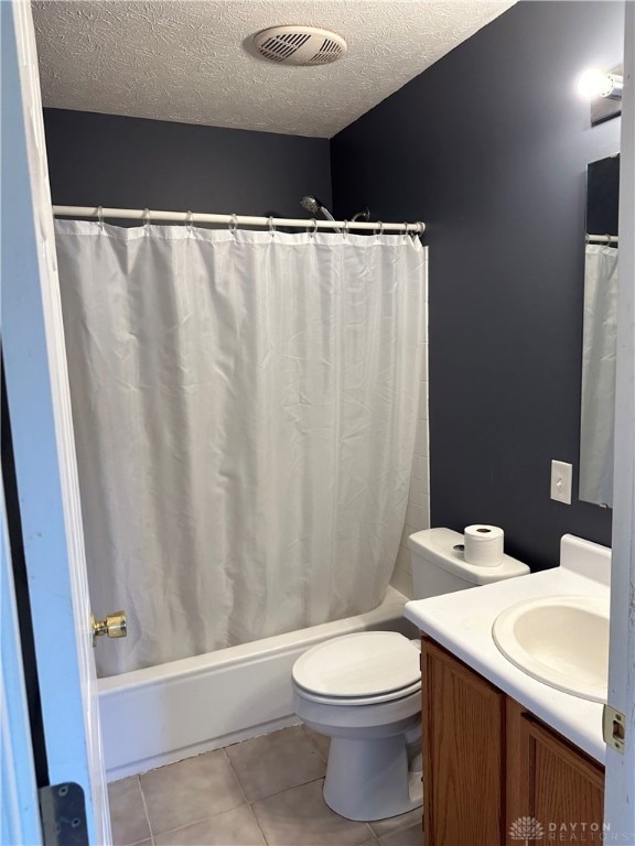 full bathroom with a textured ceiling, vanity, shower / tub combo with curtain, tile patterned flooring, and toilet