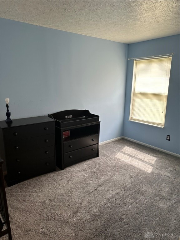 unfurnished bedroom featuring a textured ceiling and light colored carpet