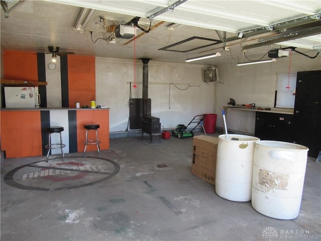 garage with white fridge, a garage door opener, and ceiling fan