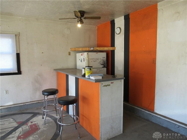 bar with ceiling fan and white refrigerator