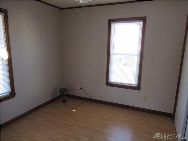 empty room with ceiling fan, light wood-type flooring, and crown molding