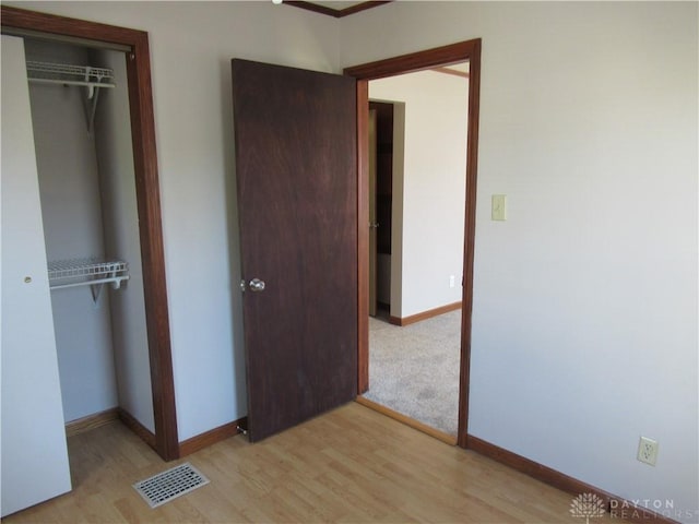 unfurnished bedroom featuring a closet and light hardwood / wood-style floors