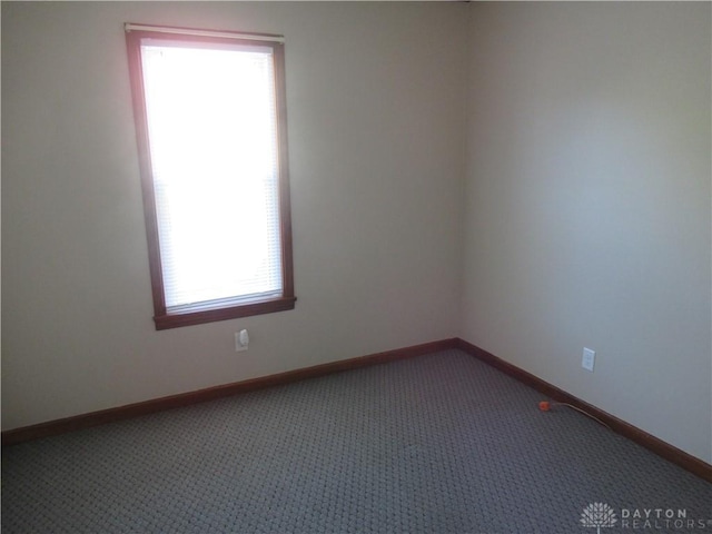 carpeted spare room featuring plenty of natural light