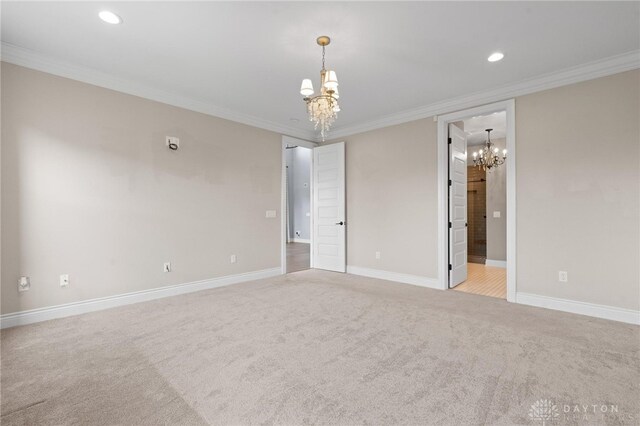 carpeted empty room with crown molding and a chandelier