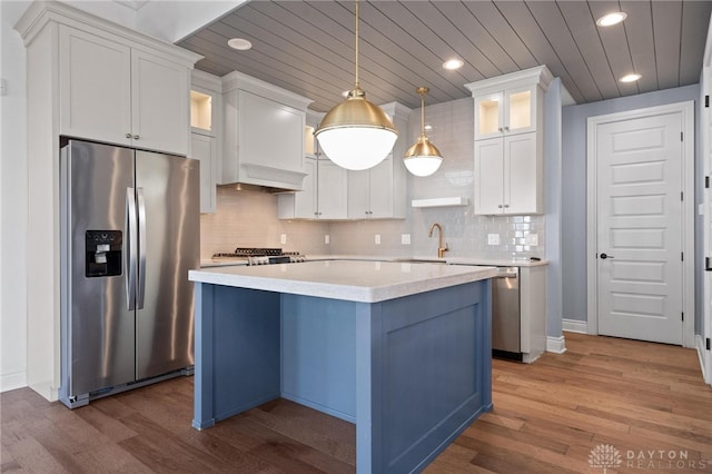 kitchen with pendant lighting, a center island, dark hardwood / wood-style floors, appliances with stainless steel finishes, and white cabinets