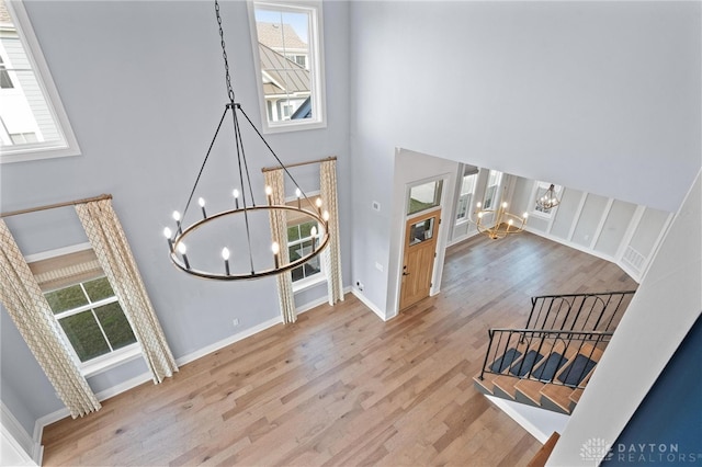 foyer featuring a wealth of natural light, light hardwood / wood-style flooring, a high ceiling, and an inviting chandelier