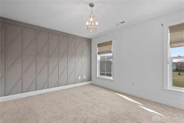 empty room featuring an inviting chandelier and carpet