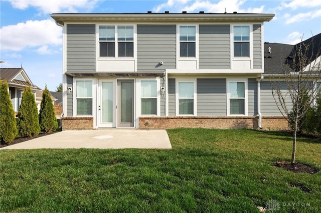 rear view of house featuring a lawn and a patio