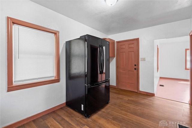 kitchen featuring black refrigerator and dark hardwood / wood-style flooring