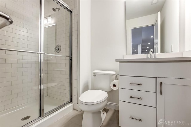 bathroom with vanity, a shower with door, and toilet