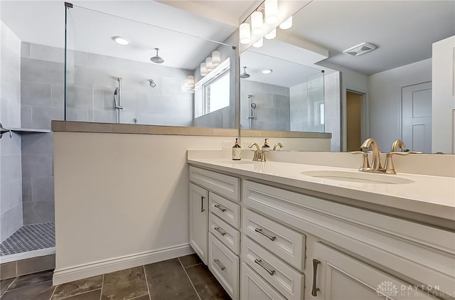 bathroom with vanity and a tile shower