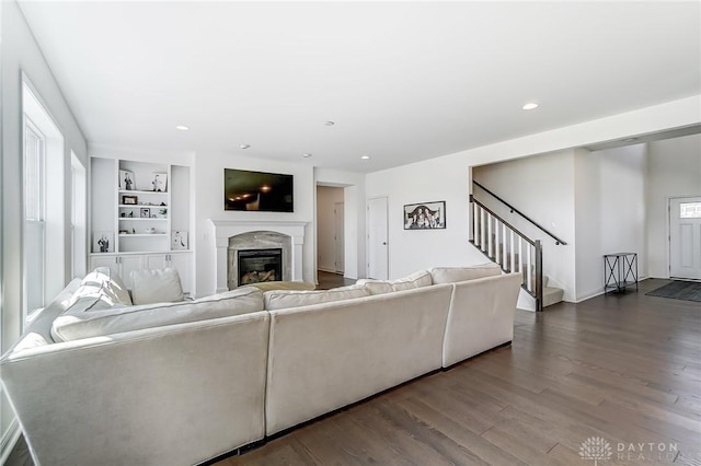 living room featuring hardwood / wood-style flooring, a fireplace, and built in shelves