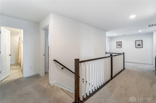 corridor featuring light colored carpet