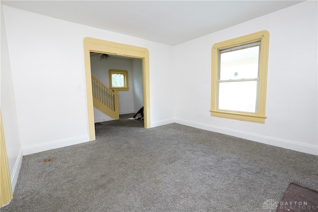 spare room featuring dark carpet