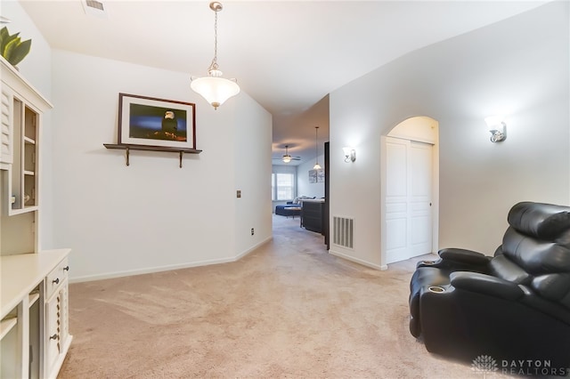 living area with vaulted ceiling, light carpet, and ceiling fan