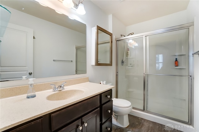 bathroom with vanity, toilet, hardwood / wood-style floors, and an enclosed shower