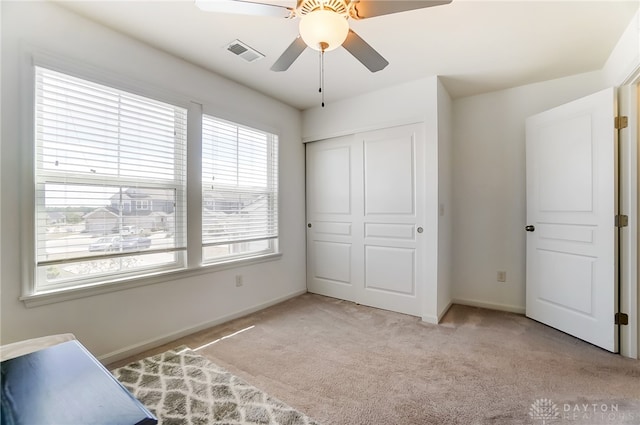 bedroom with light carpet, ceiling fan, and a closet