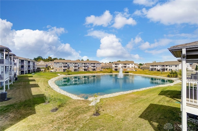 view of pool featuring a water view and a lawn