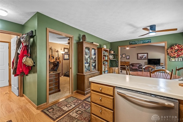 kitchen featuring ceiling fan, dishwasher, light hardwood / wood-style floors, and a textured ceiling