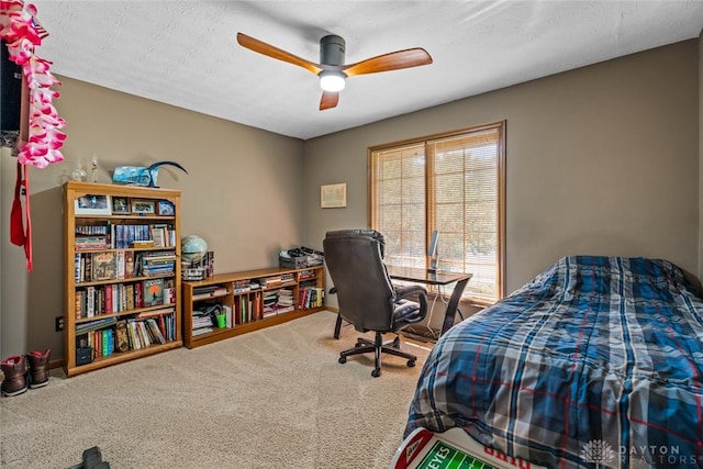 carpeted bedroom featuring ceiling fan and a textured ceiling