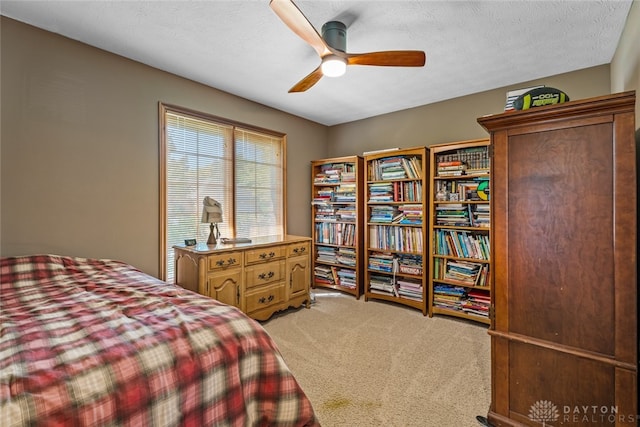 carpeted bedroom featuring a textured ceiling and ceiling fan