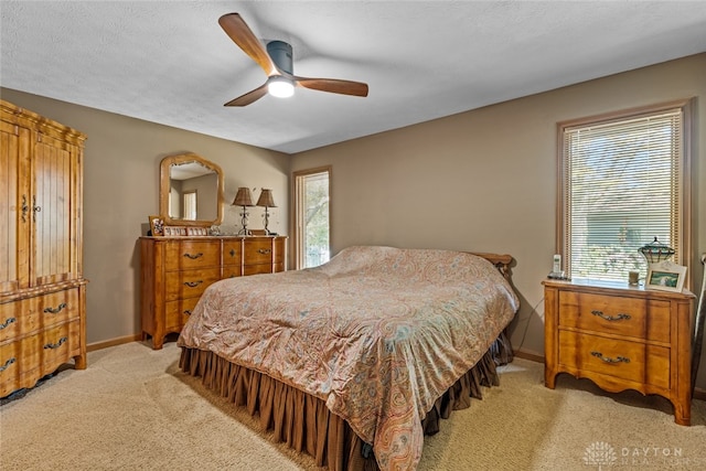 bedroom featuring ceiling fan, light carpet, and multiple windows