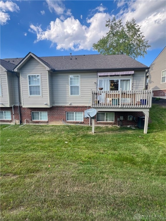 rear view of house featuring a deck and a lawn