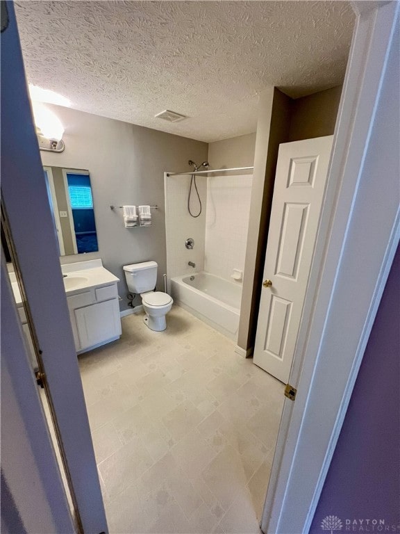 full bathroom featuring vanity, a textured ceiling, toilet, and washtub / shower combination