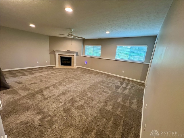 unfurnished living room featuring a textured ceiling, carpet flooring, and ceiling fan