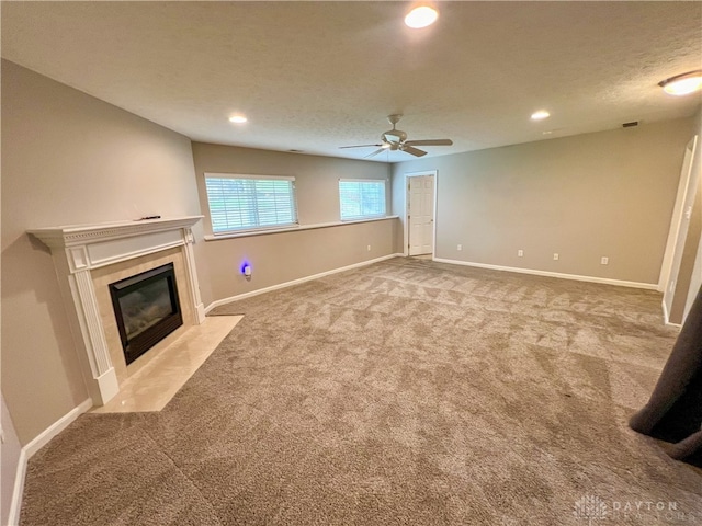 unfurnished living room with light carpet, a textured ceiling, and ceiling fan