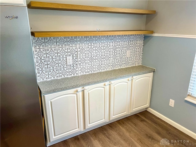 kitchen featuring stainless steel fridge, decorative backsplash, white cabinetry, and dark hardwood / wood-style floors