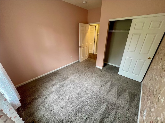 unfurnished bedroom featuring a closet and dark colored carpet