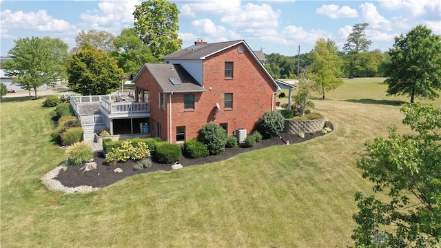 view of side of home with a lawn, a wooden deck, and central AC unit