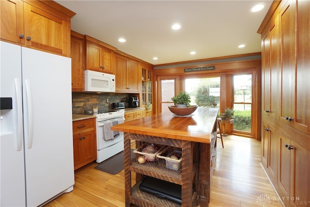 kitchen featuring white appliances, backsplash, light hardwood / wood-style floors, and wood counters