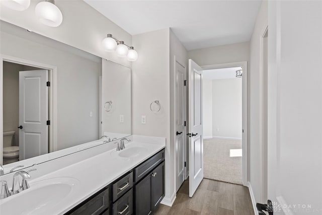 bathroom with toilet, hardwood / wood-style flooring, and vanity