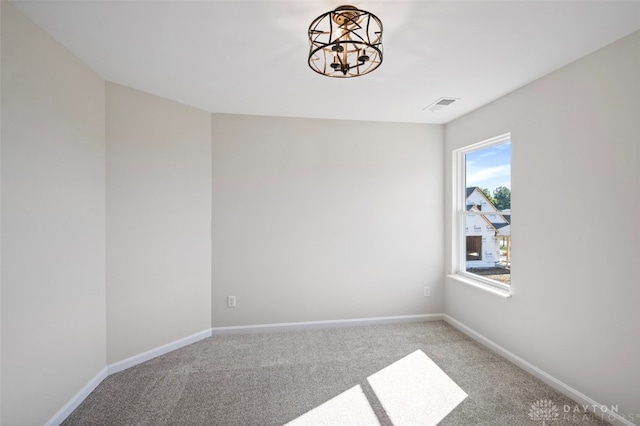 unfurnished room with a chandelier and light colored carpet