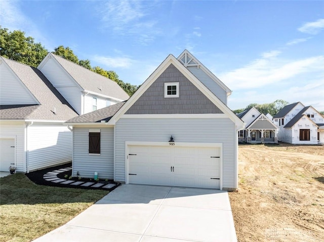 view of front of home featuring driveway, a front lawn, and an attached garage