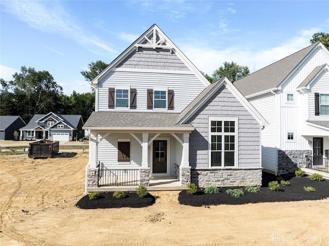 craftsman-style house featuring a porch, stone siding, and a shingled roof