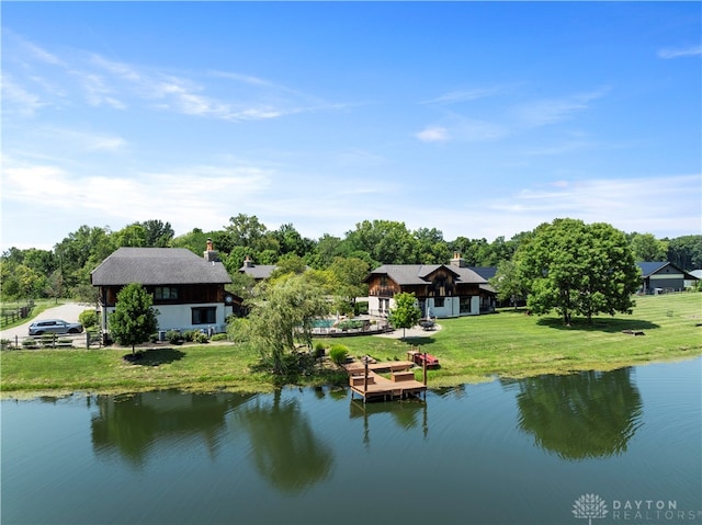 rear view of property featuring a water view and a yard