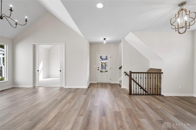 foyer entrance featuring baseboards, a notable chandelier, and wood finished floors