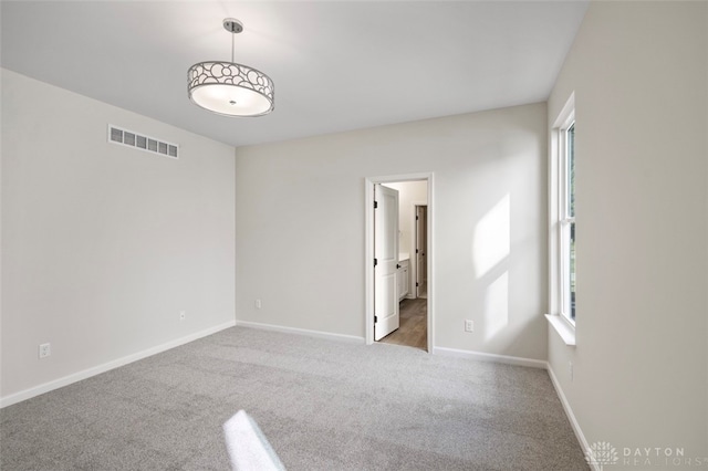 spare room featuring light colored carpet