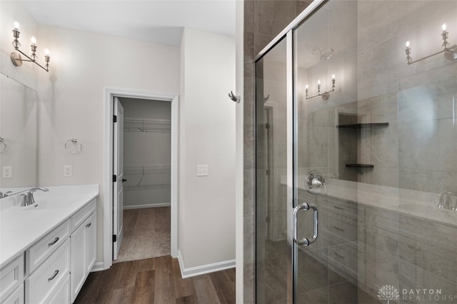 bathroom featuring wood-type flooring, walk in shower, and vanity