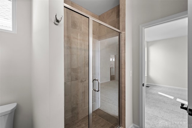 bathroom featuring walk in shower and toilet